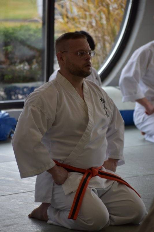 John Syc during Kyokushin karate belt test, demonstrating focus and discipline.